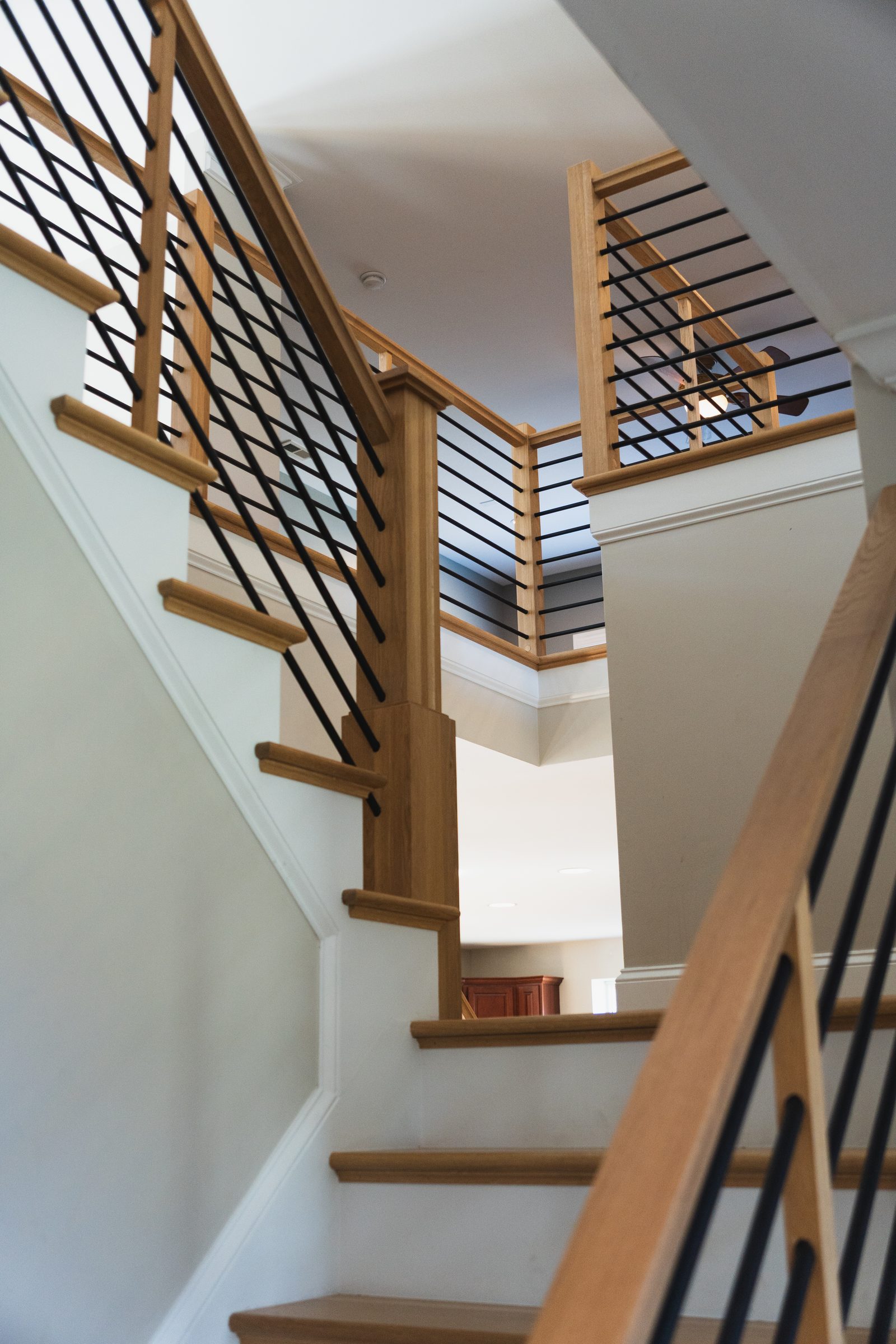 Escada com corrimão de madeira e barras de metal feita pela Dr. Stairs