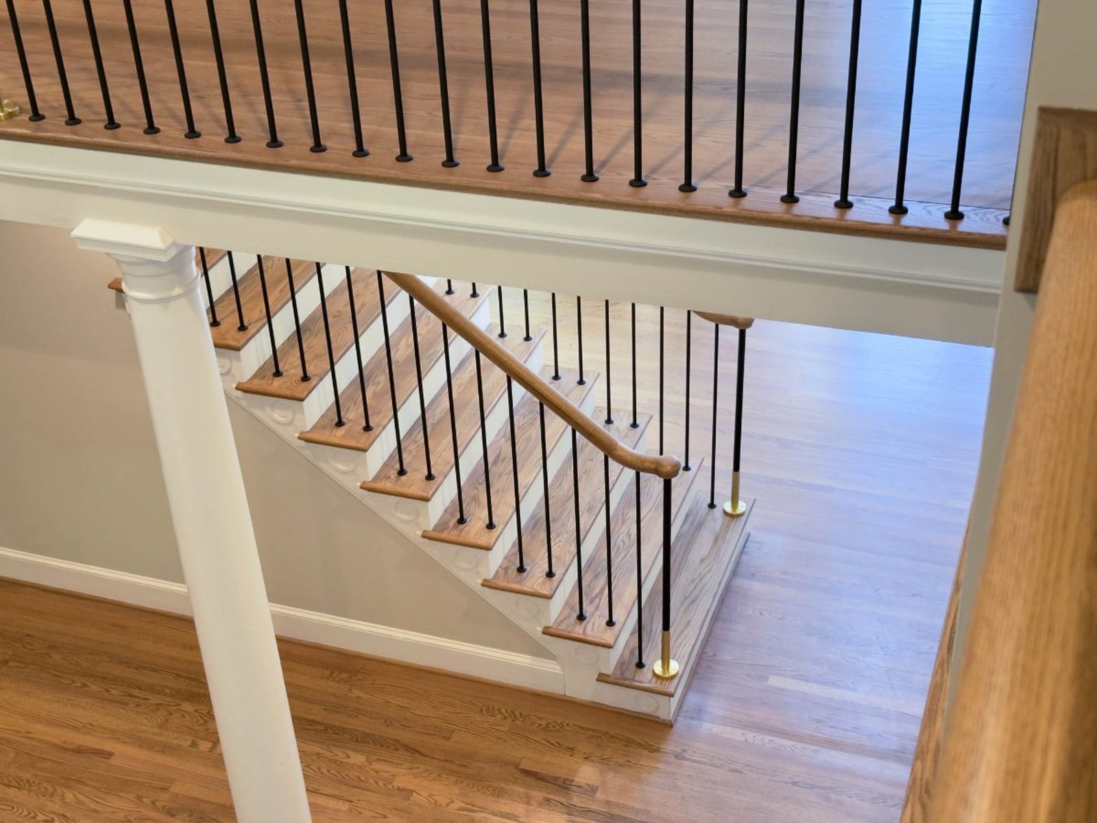 Escada modelo Soho da Dr. Stairs com barras metálicas pretas e detalhes dourados
